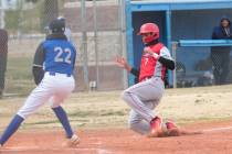 Doral Academy's Sebastian Zaman (7) slides into home base to score a run in front of Desert Pin ...