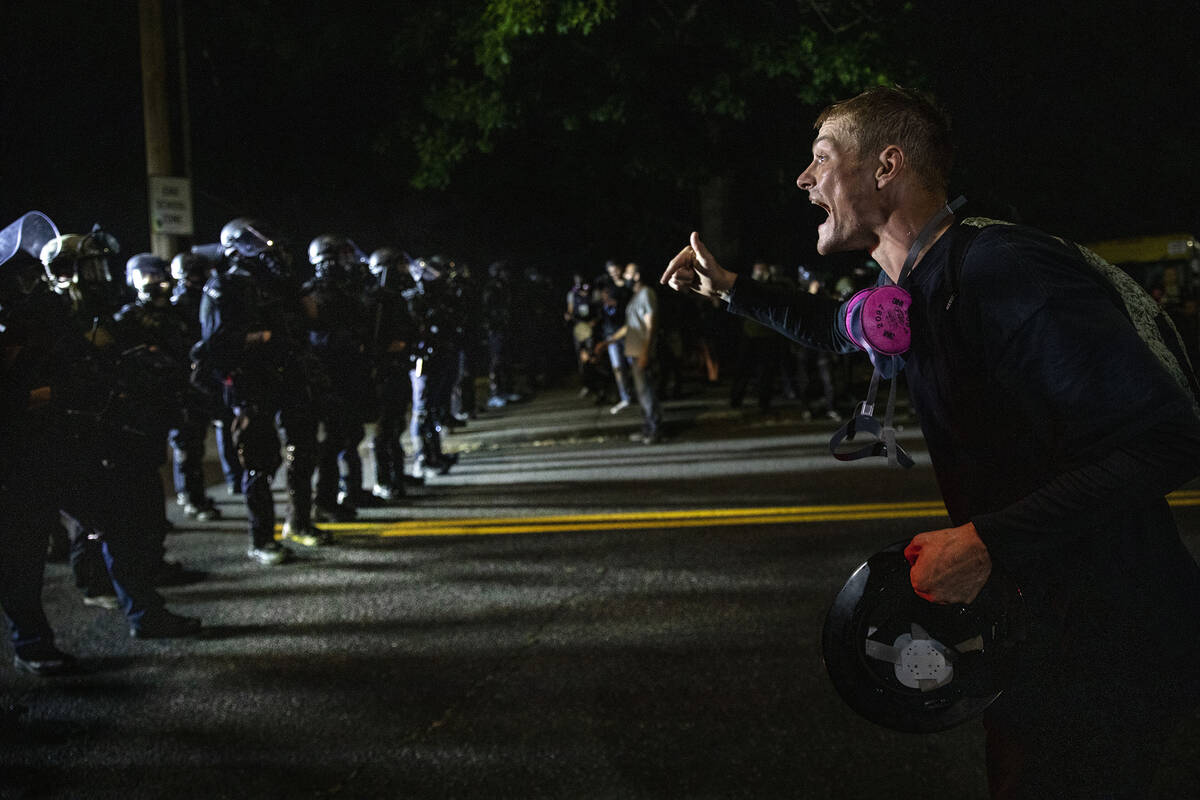A protester screams at police as as Portland protests continue reaching 100 consecutive nights ...