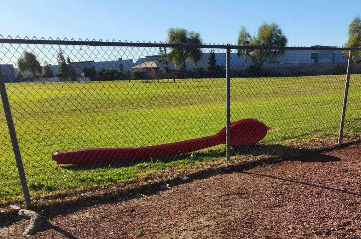 This photo shows a 15-foot red spoon lying behind a fence in Phoenix on Monday, April 3, 2023. ...