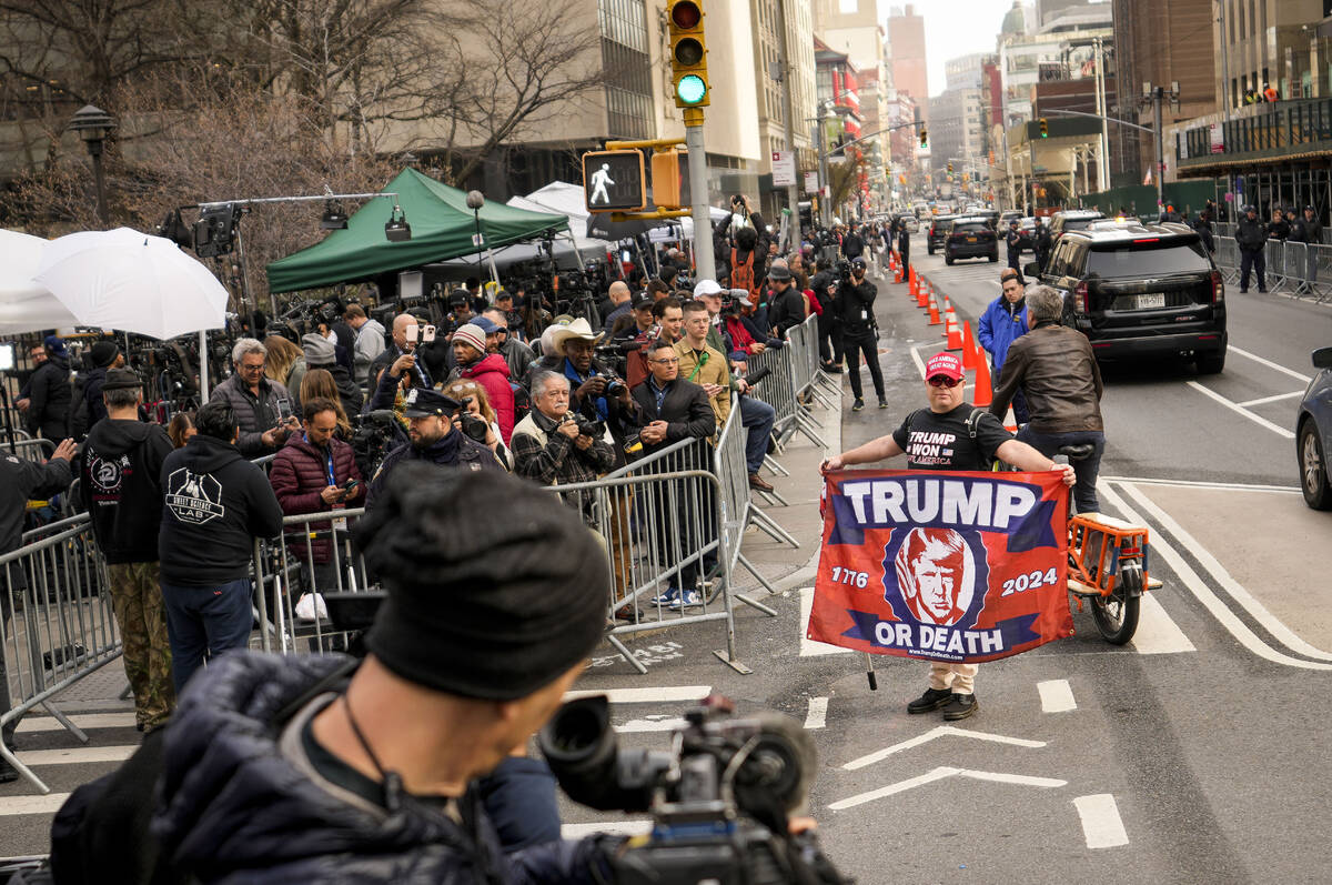 Supporters of Former President Donald Trump gather in front of assembled media and onlookers ou ...