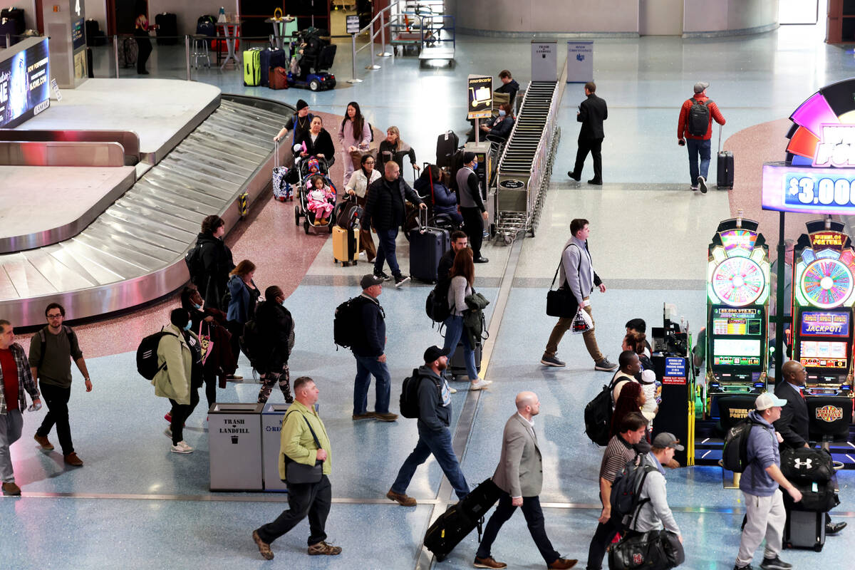 Passengers walk through baggage claim in Terminal 1 at Harry Reid International Airport in Las ...