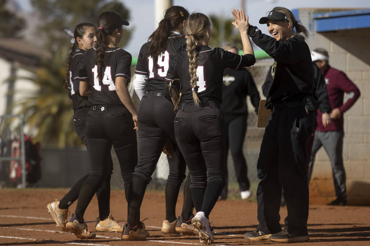 Faith Lutheran coach Amanda Roark slaps hands with pitcher Jersie McDonald (4) during a high sc ...