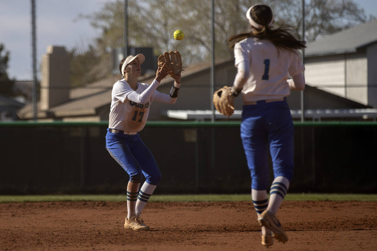 Green Valley’s McKenna Young reaches to catch a hit by Faith Lutheran while Gabby Machid ...