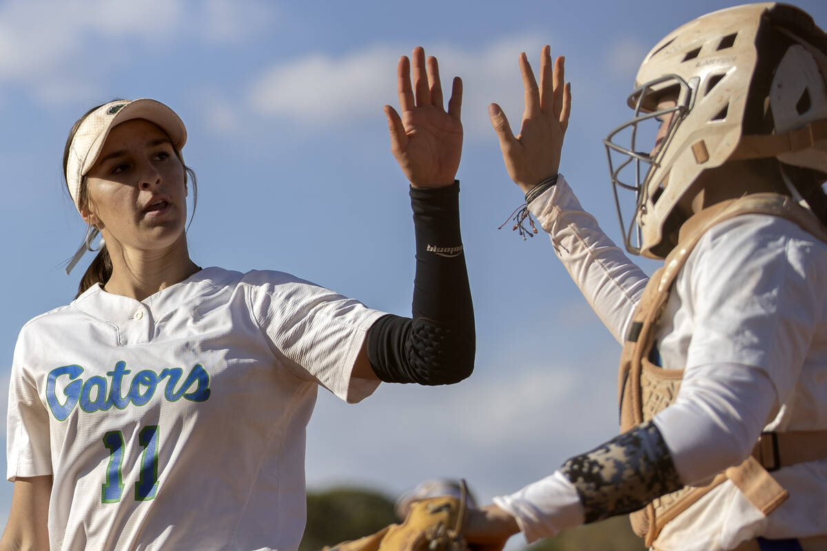 Green Valley’s Avari Morris slaps catch with Rustie Riley during a high school softball ...