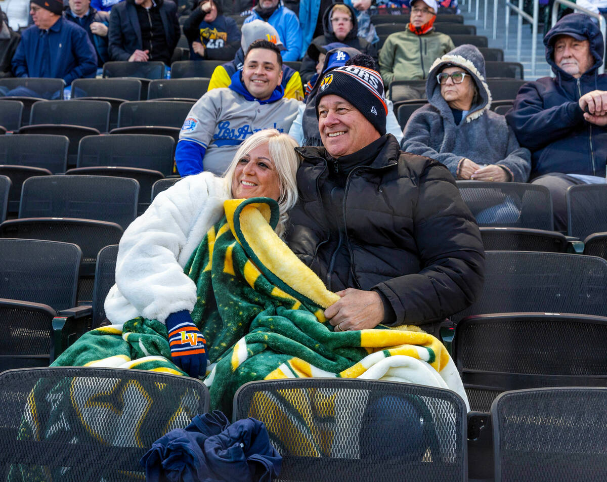 Fans Kendall, left, and Dane Brooks stay warm under their Oakland A's blanket as the Aviators f ...