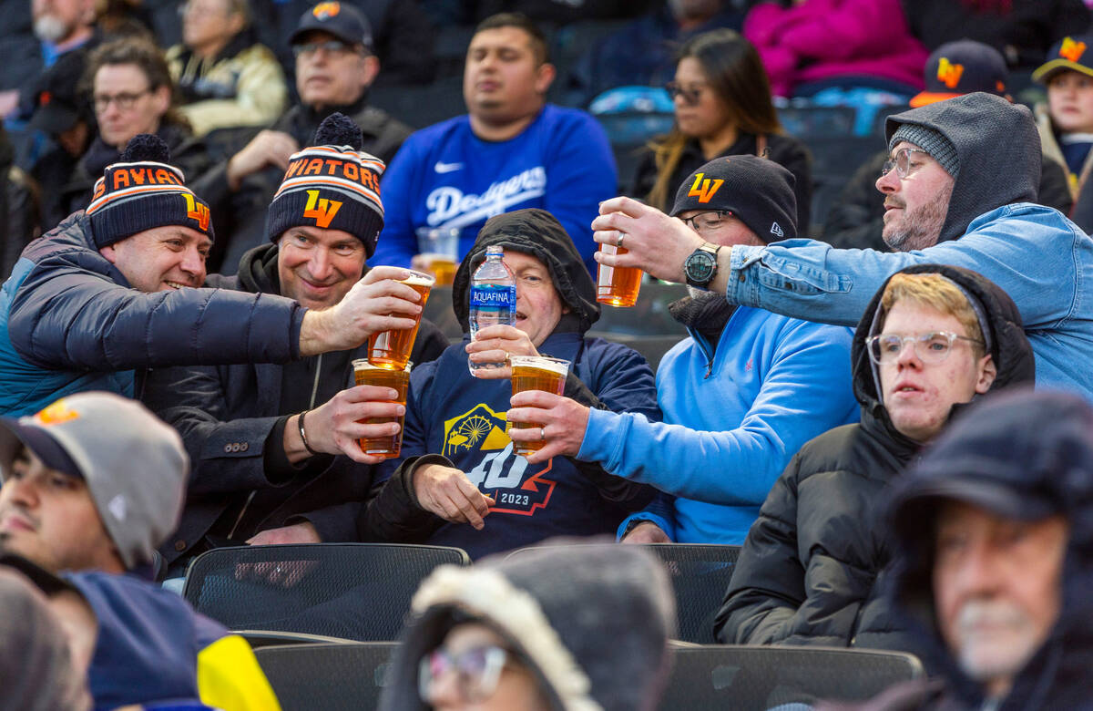 Fans toast the evening fun during the first inning of the Aviators against Dodgers during their ...