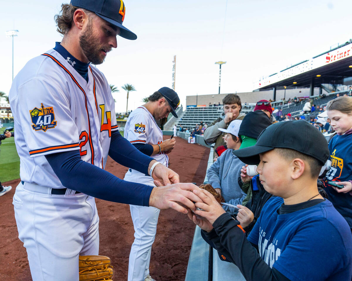 Aviators outfielder Cody Thomas (12) signs a ball for a young fan before the first inning of th ...