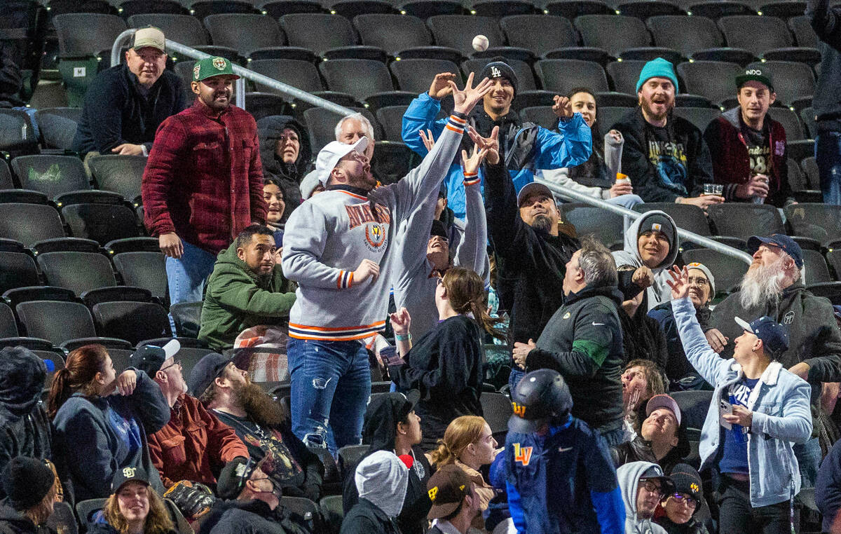Fans reach for a ball in the stands as the Aviators face the Dodgers during the second inning o ...