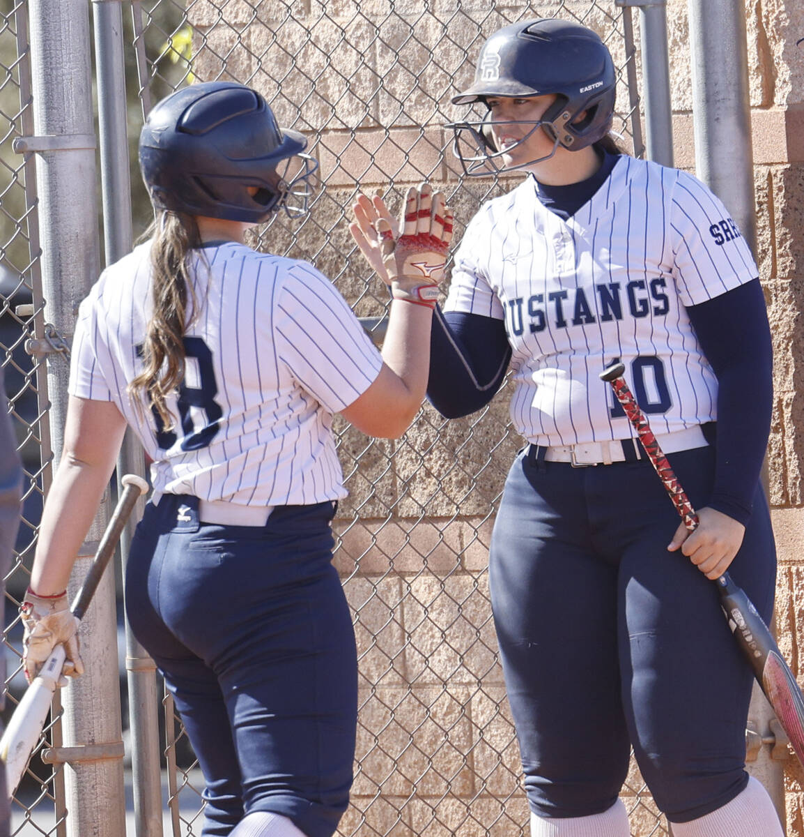 Shadow Ridge's Maddie Foster (18) gets a high-five from her teammate Abby Covington (10) after ...
