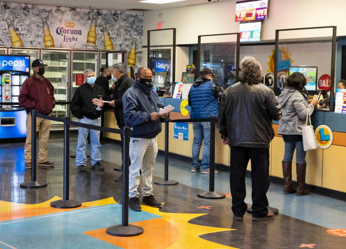 People line up inside of the Prime Valley Lotto Store as they wait to buy the Mega Million and ...