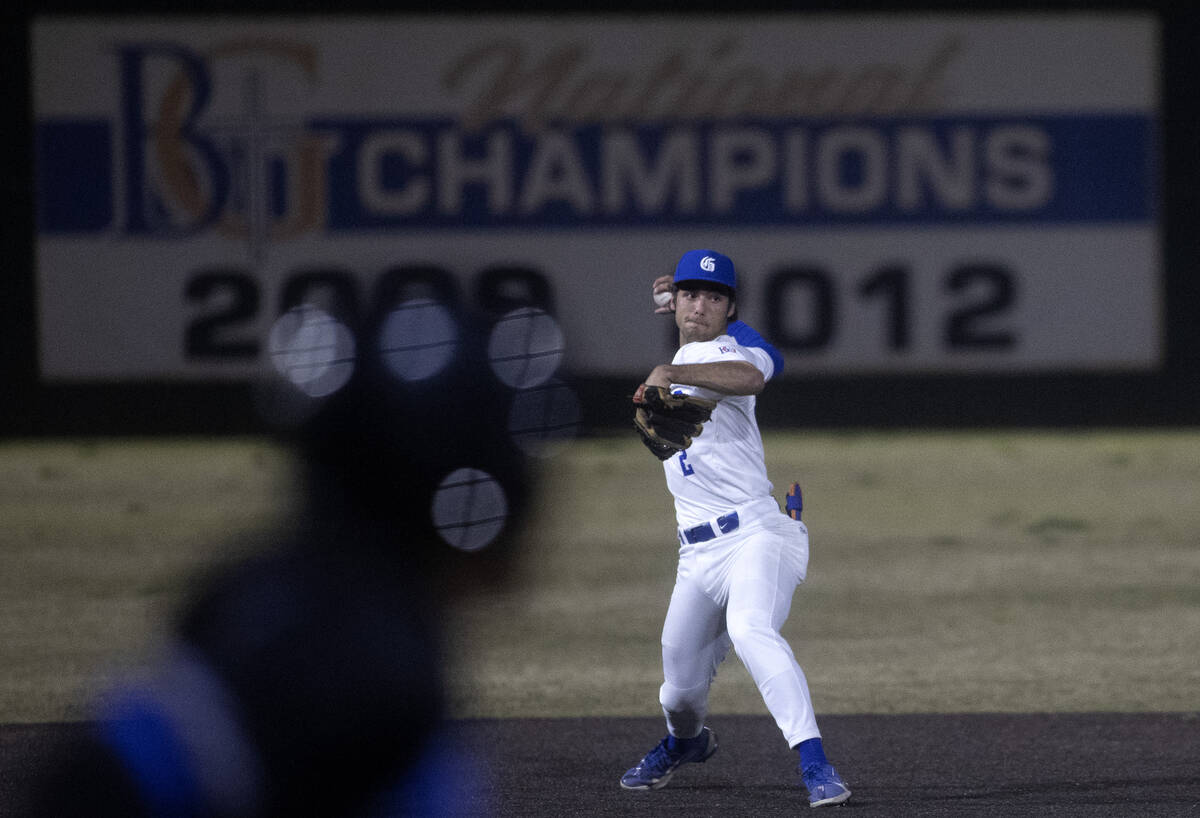 Bishop Gorman second baseman Maddox Riske throws to first for an out as Basic attempts to make ...
