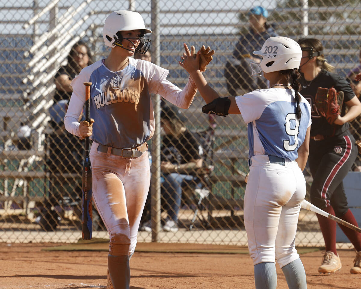 Centennial's Jill Halas (11) gets a high-five from her teammate Centennial's Amanda Campos-Colo ...