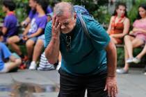 Russ Wilson splashes water on his face from a fountain in New York, Wednesday, July 17, 2019. T ...