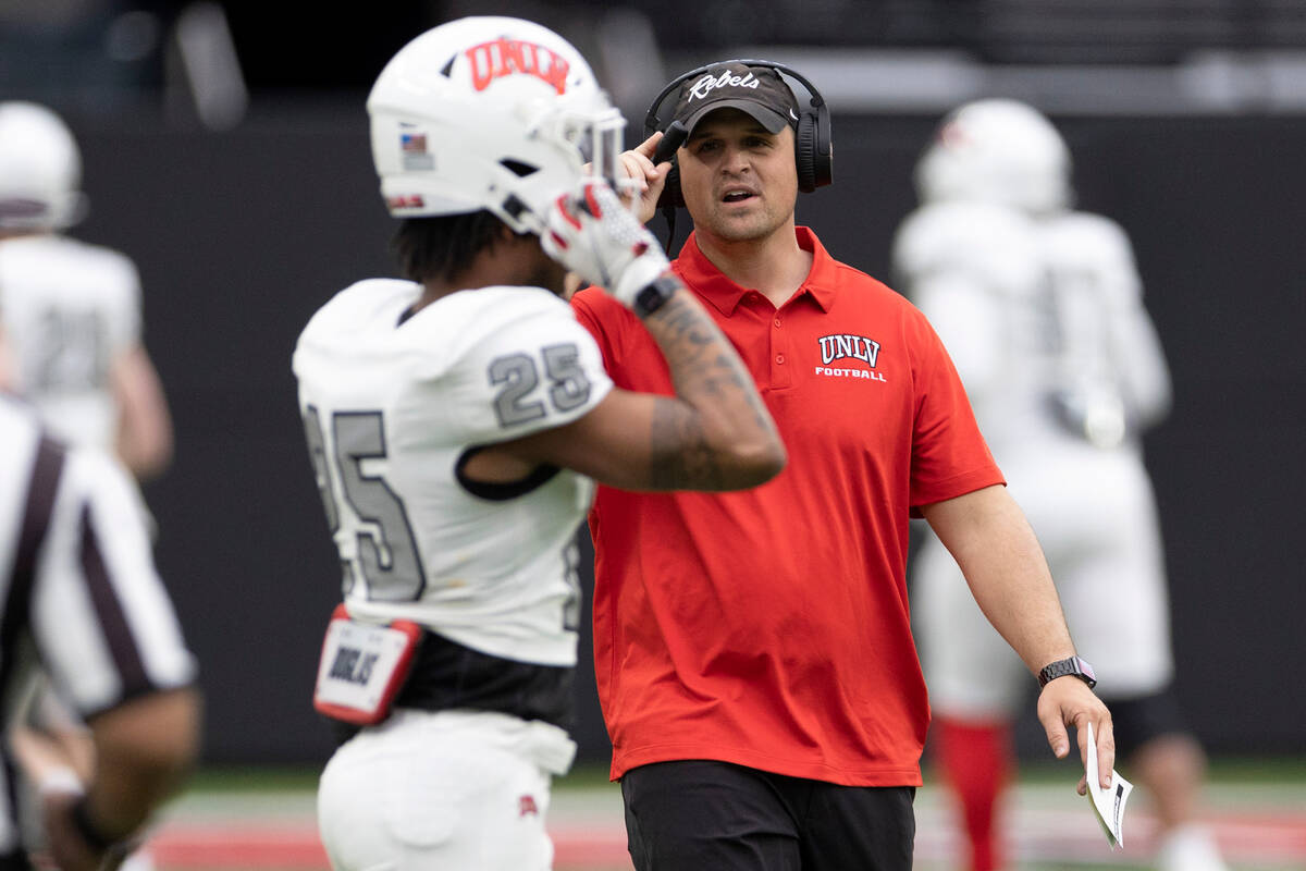 Defensive coordinator Mike Scherer communicates with defensive back Jordyn Morgan (25) during t ...