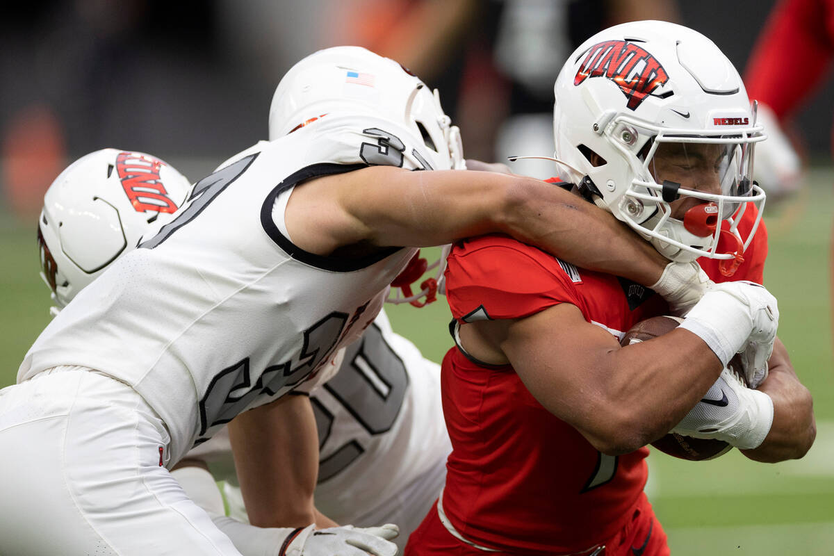 Wide receiver Jacob De Jesus is taken down by defensive back Davone Walden Jr. during the UNLV ...