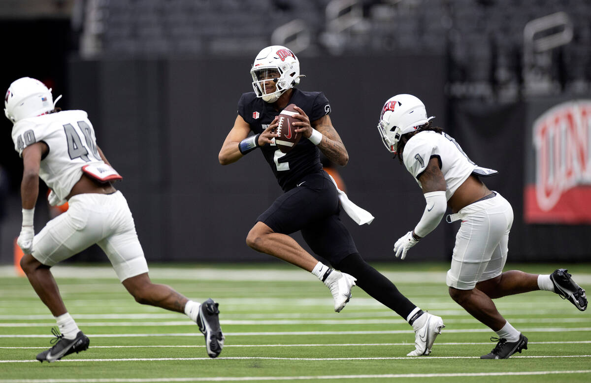 Quarterback Doug Brumfield (2) looks to pass while defensive backs Daego Albert (40) and Jalen ...