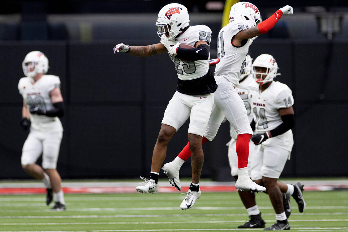 Defensive backs Jordyn Morgan (25) and BJ Harris (21) celebrate a tackle during the UNLV spring ...
