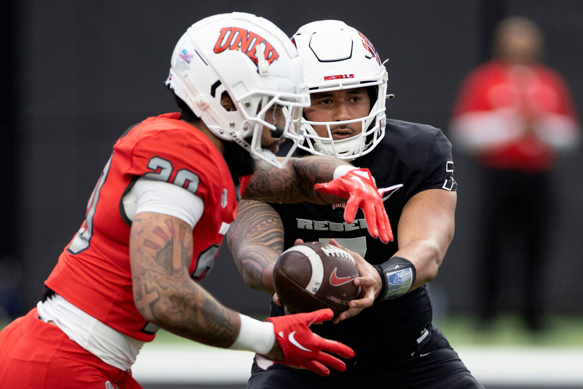 Quarterback Cameron Friel (7) hands the ball off to running back Jayvaun Wilson (20) during the ...