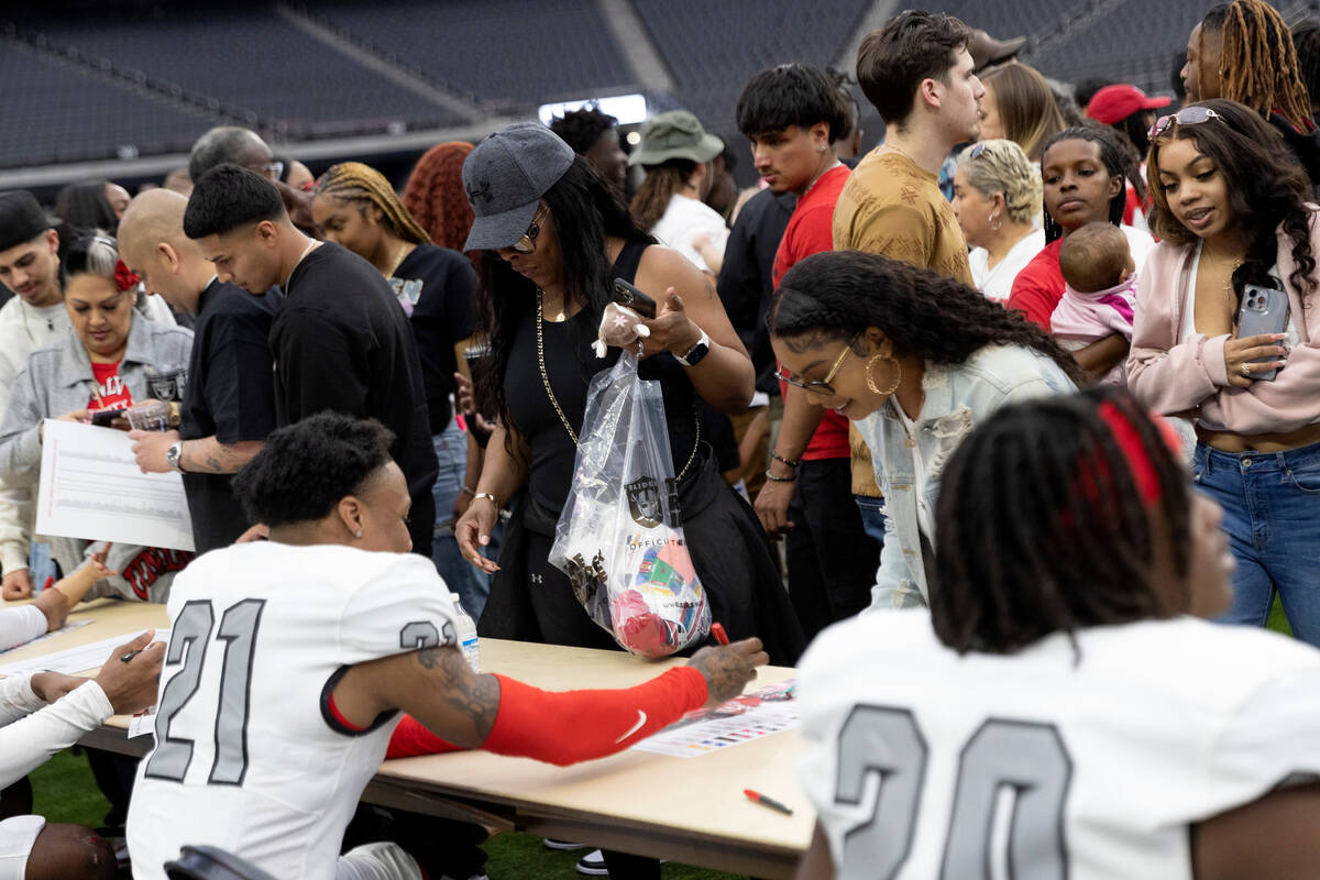 Players sign autographs for fans after the UNLV spring showcase game at Allegiant Stadium on Sa ...