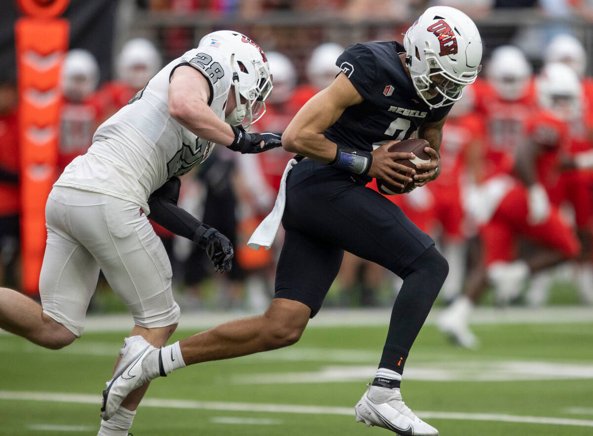 UNLV quarterback Doug Brumfield (2) is forced out of the pocket by linebacker Fisher Carmac (28 ...