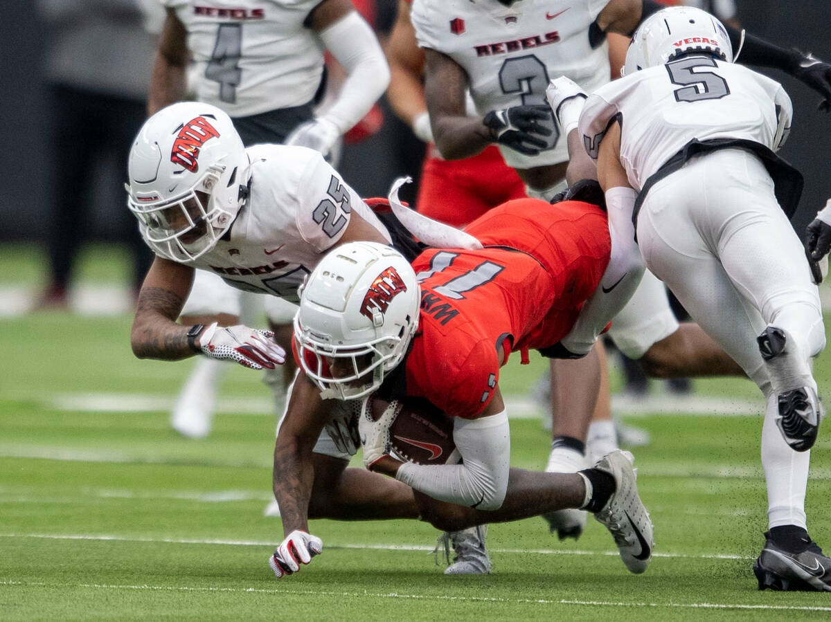 UNLV wide receiver Ricky White (11) dives for more yards as he is tackled by defensive back Jor ...