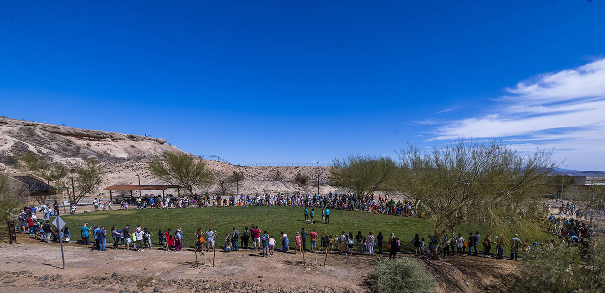 Parents and children ages 4-7 gather around a field for the next egg hunt to start during the a ...