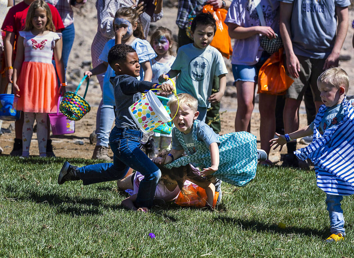 Children collide attempting to get a quick start as the egg hunt begins for ages 4-7 during the ...