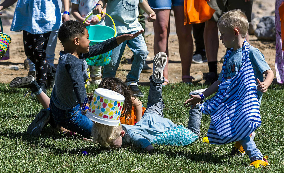 Children collide attempting to get a quick start as the egg hunt begins for ages 4-7 during the ...