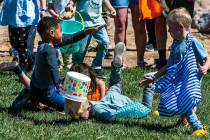 Children collide attempting to get a quick start as the egg hunt begins for ages 4-7 during the ...
