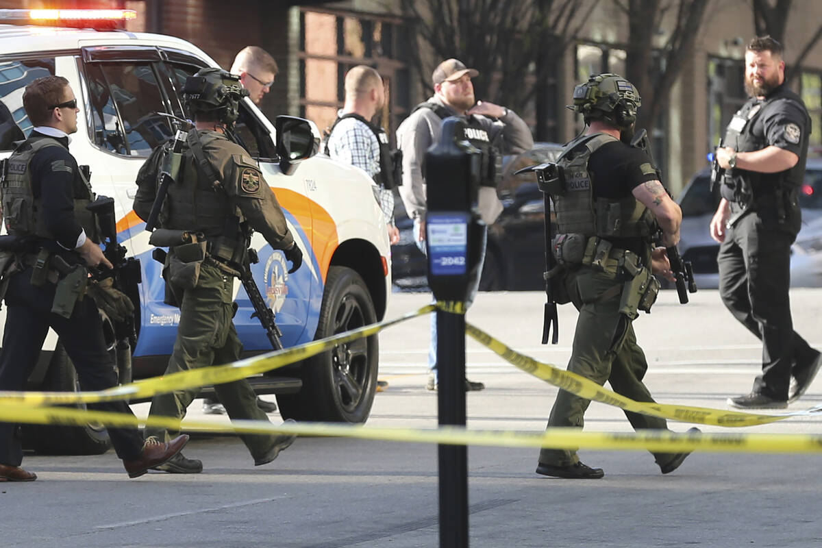 Multiple agencies arrive at a building after a shooting took place in Louisville, Ky., Monday, ...