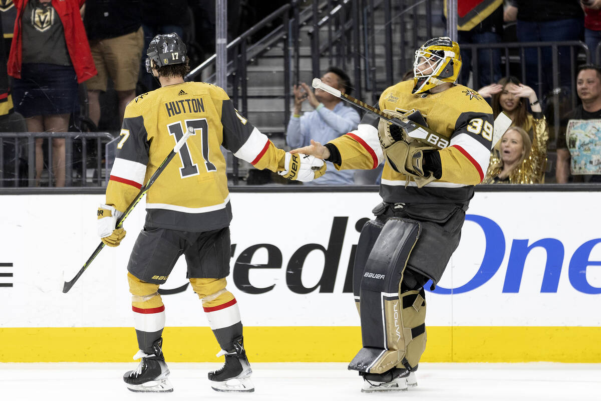 Golden Knights defenseman Ben Hutton (17) and goaltender Laurent Brossoit (39) slap hands after ...