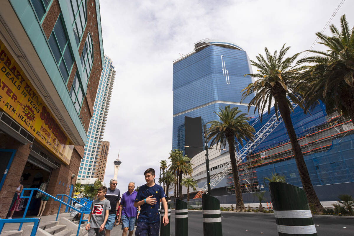 Pedestrians walk past the under-construction Fontainebleau Las Vegas, right, on Wednesday, Apri ...