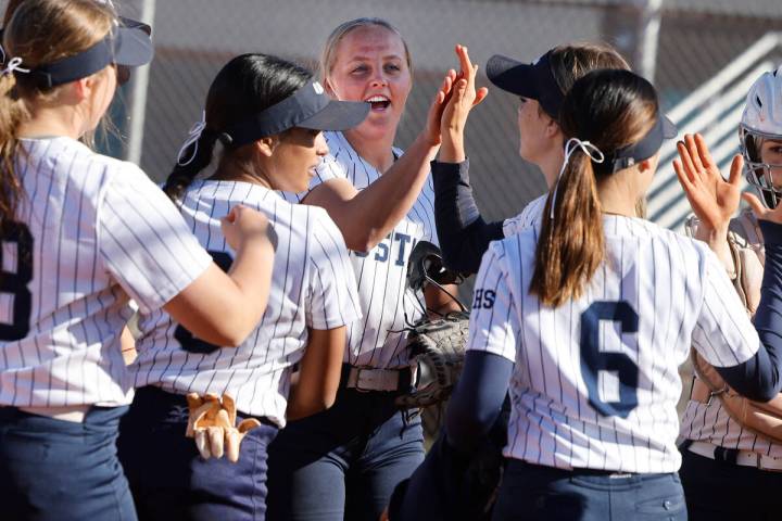 Shadow Ridge pitcher Josslin Law (4), center, and catcher Jacobi Gledill (13), right, get high- ...