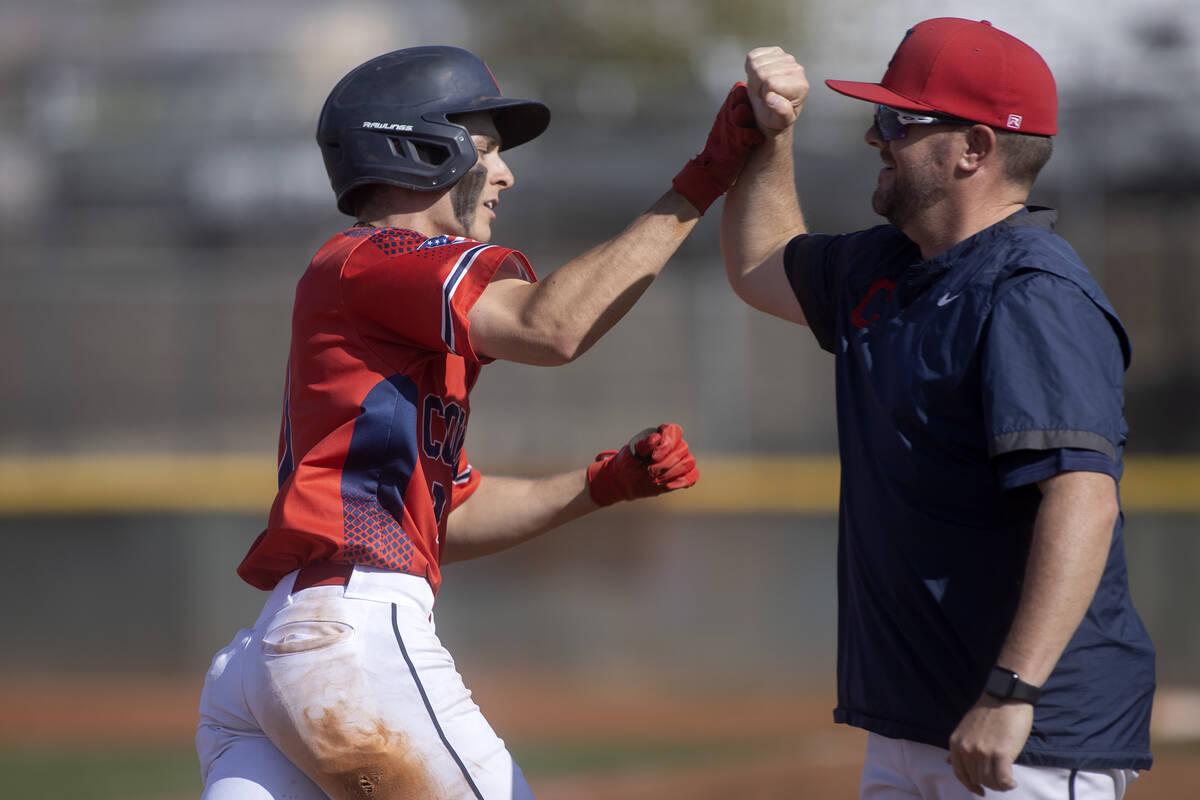 Coronado’s Evan Festa bumps fists with head coach Garrett Smith after scoring a home run ...