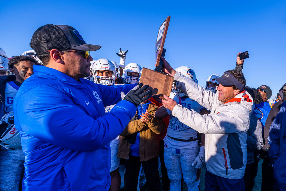 Bishop Gorman head coach Brent Browner receives the winning trophy from NIAA Executive Director ...