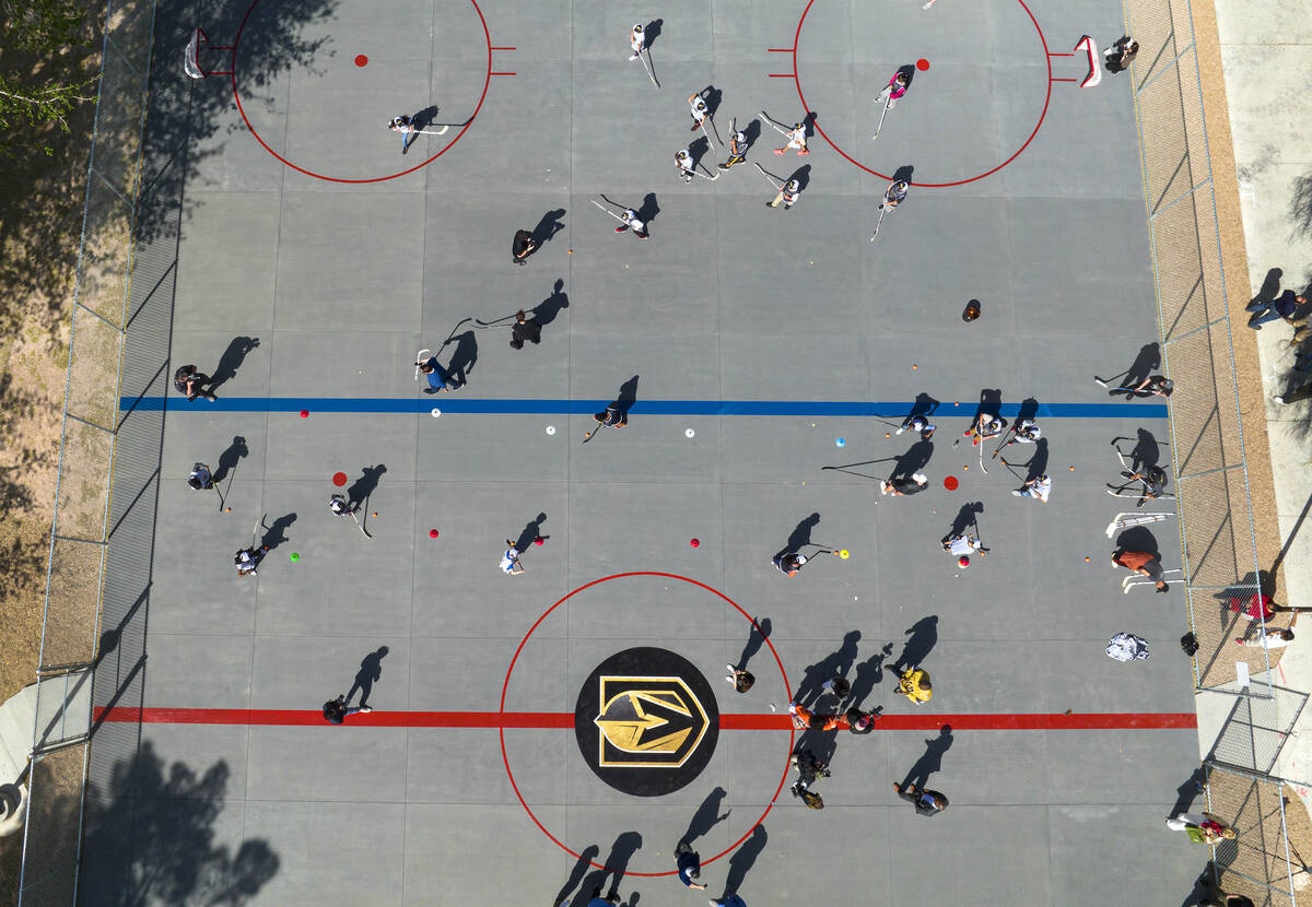 Children play on the Vegas Golden Kight's Ball Hockey Rink at Lorenzi Park after the ribbon cut ...