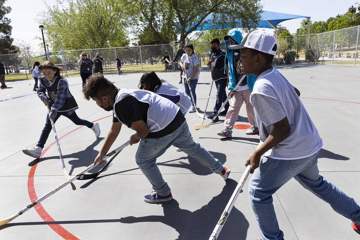 Children play on the Vegas Golden Kight's Ball Hockey Rink at Lorenzi Park after the ribbon cut ...