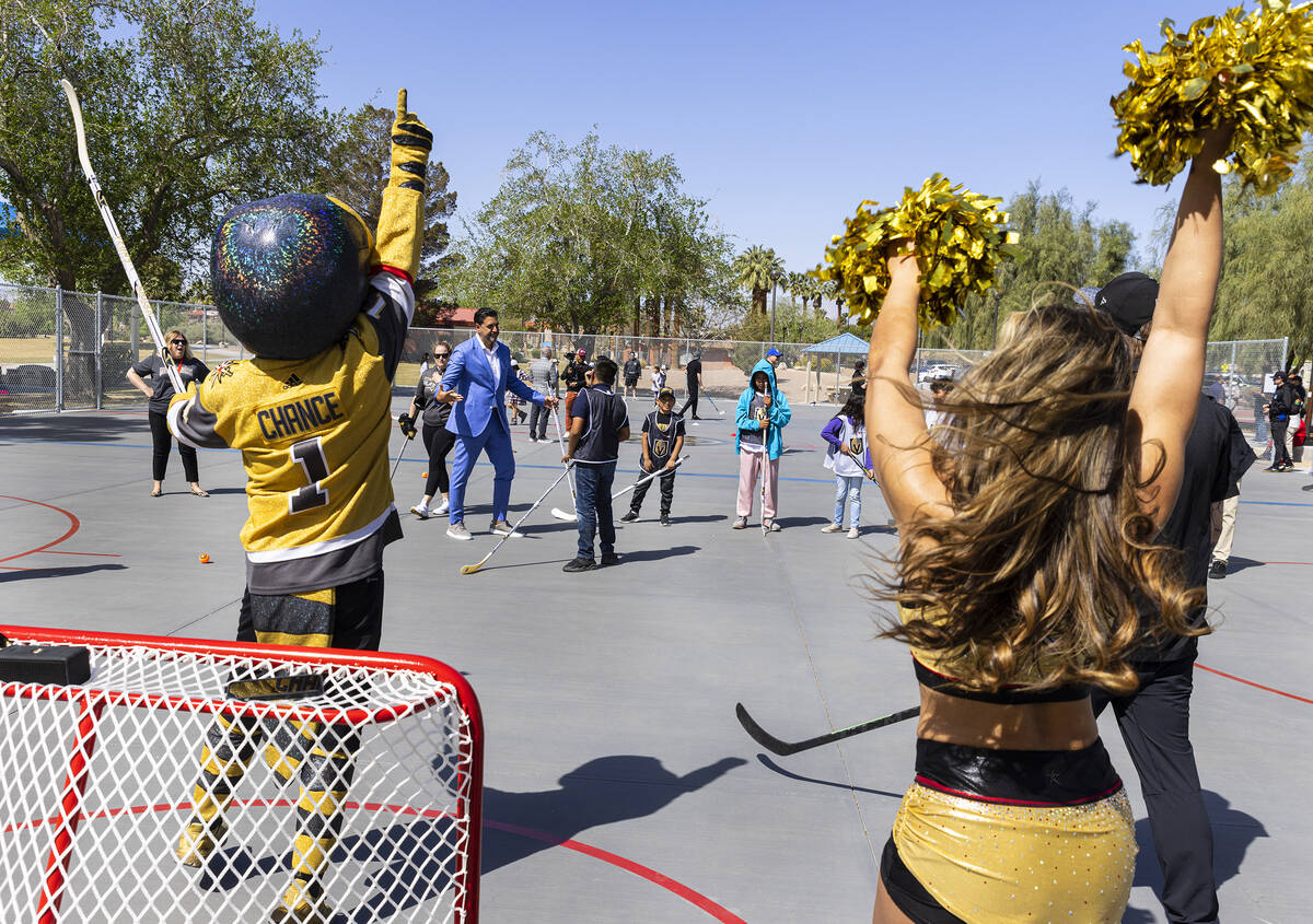 Angel Campos, 10, center, is congratulated by Rob Knesaurek, NHL Senior Vice President, Youth D ...