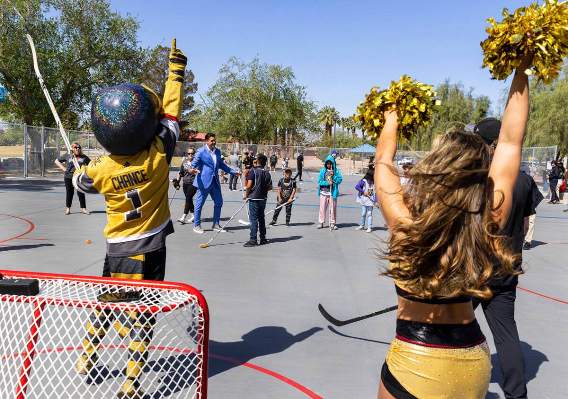 Angel Campos, 10, center, is congratulated by Rob Knesaurek, NHL Senior Vice President, Youth D ...