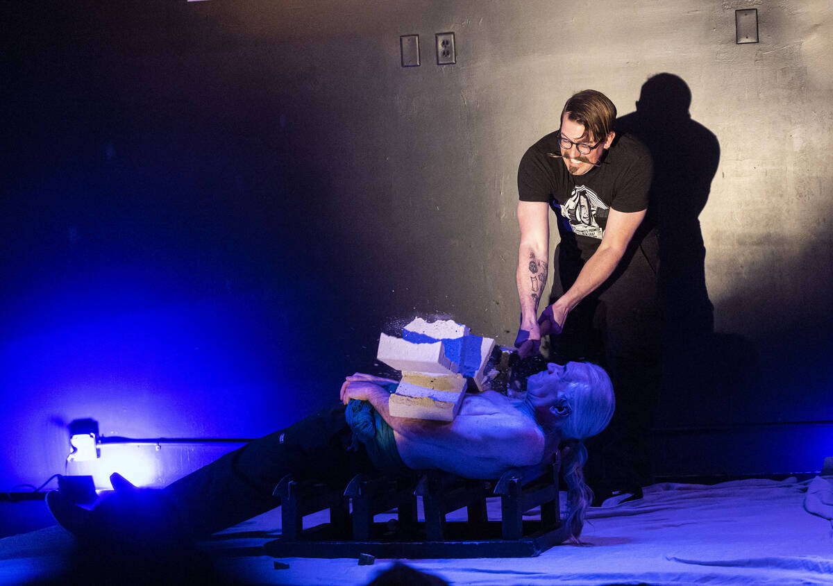 An audience member smashes a cinderblock atop Zamora the Torture King, lying down on blades, du ...