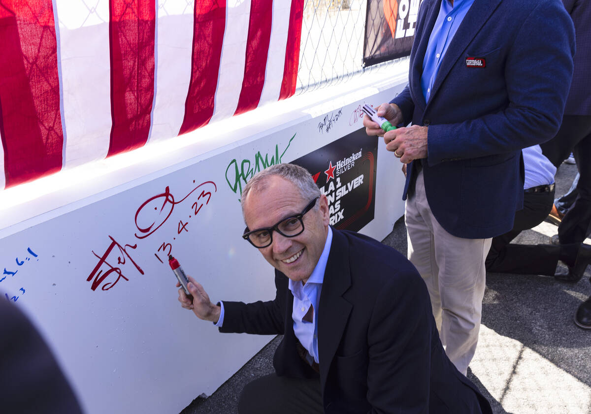 Formula One CEO Stefano Domenicali, poses for a photo after signing on a barrier during a toppi ...