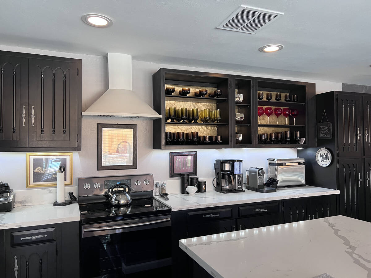 The chef's kitchen features the original custom cabinetry, quartz counters and updated applianc ...
