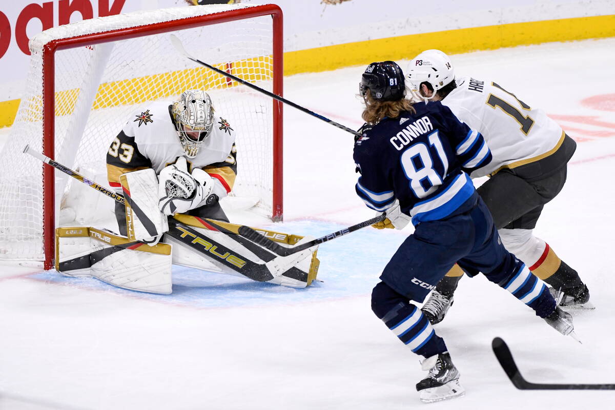 Vegas Golden Knights goaltender Adin Hill (33) makes a save on Winnipeg Jets' Kyle Connor (81) ...