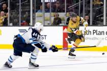 Golden Knights center Jack Eichel (9) takes a shot on the empty goal while Jets defenseman Josh ...