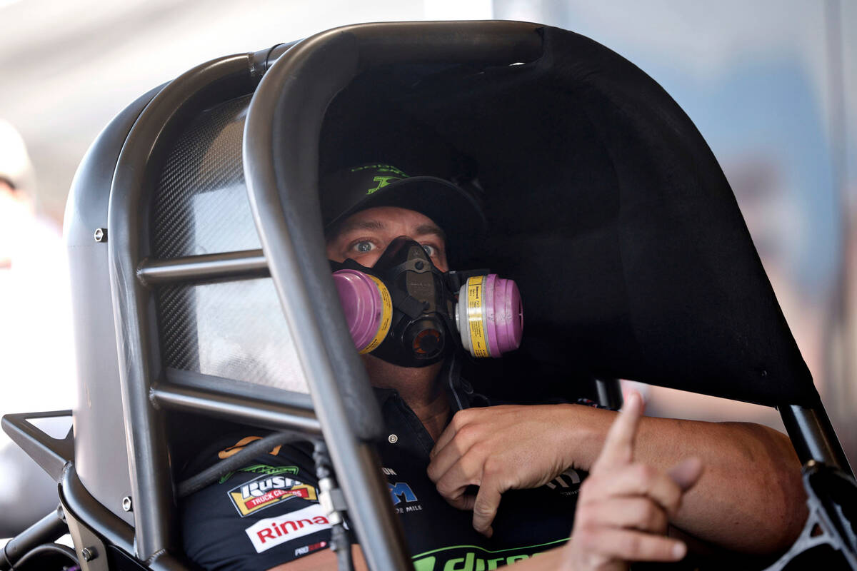 NHRA driver Matt Hagan gestures in his funny car as his crew checks the car before the first Ni ...