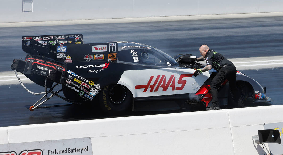 A crew member checks NHRA driver Matt Hagan’s funny car before the first Nitro qualifyin ...