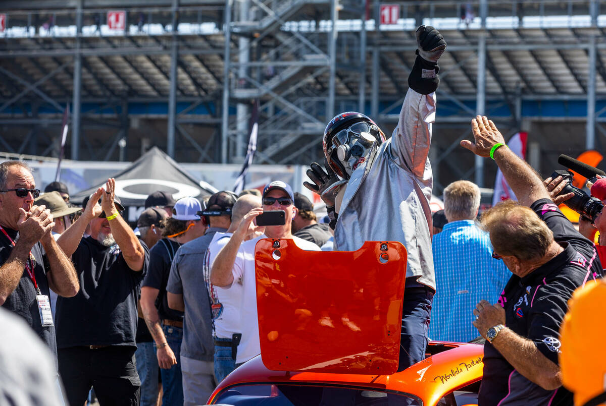Funny Car driver Cruz Pedregon poses after starting up his fathers's former racing car in the p ...