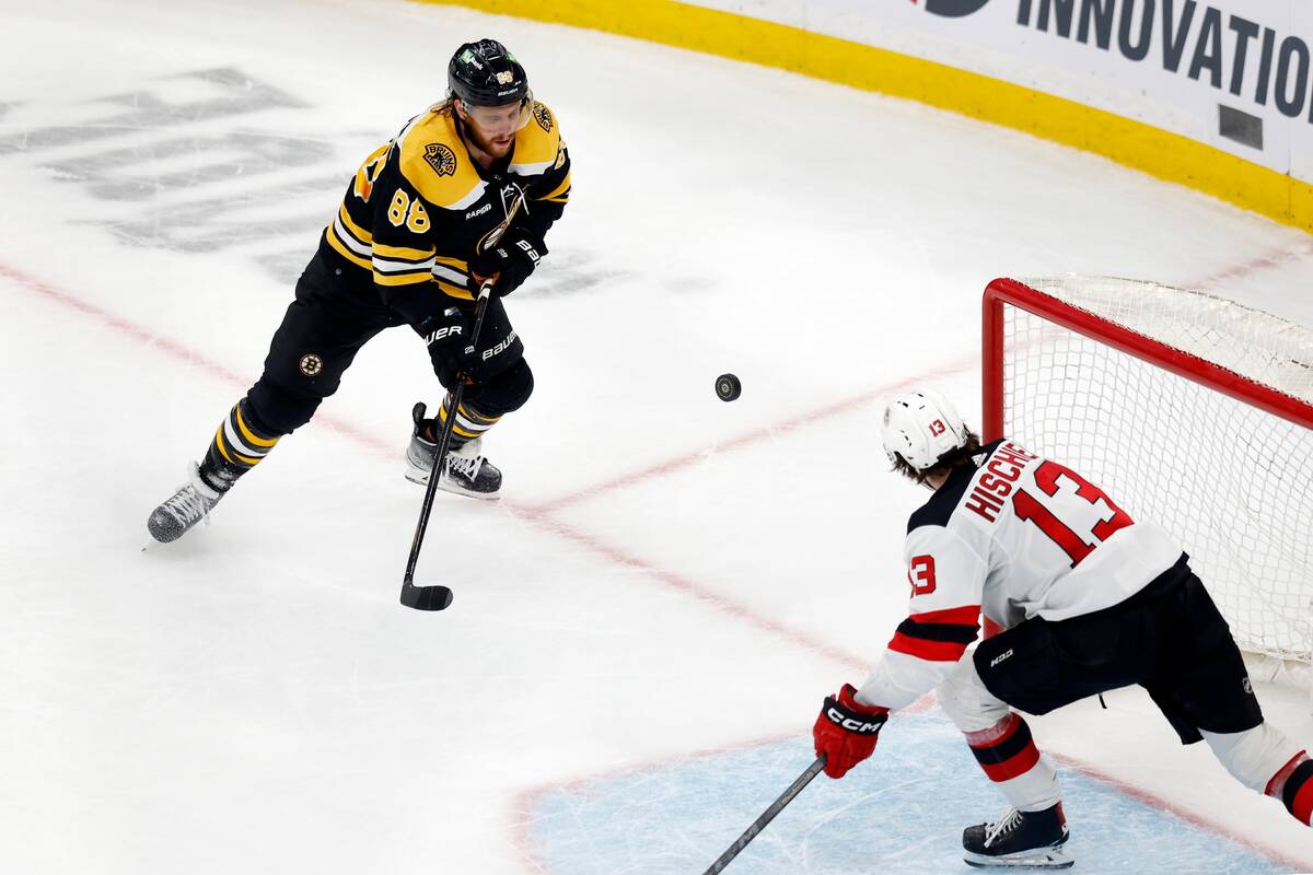New Jersey Devils' Nico Hischier (13) defends the empty net as Boston Bruins' David Pastrnak (8 ...