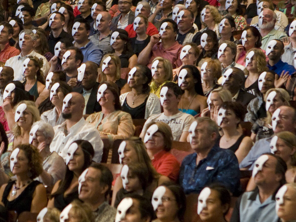 Members of the audience wear phantom masks prior to the start of the fourth anniversary perform ...