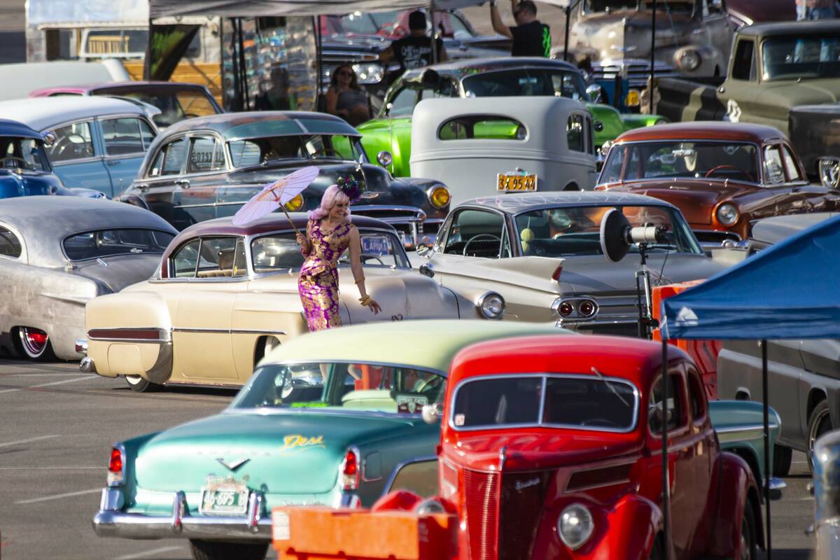 A model poses as vintage vehicles are set up ahead of the car show during the first day of Viva ...